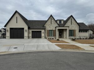 A large, elegant house featuring light gray board and batten siding and stone accents by New Look Siding in Midvale, UT.