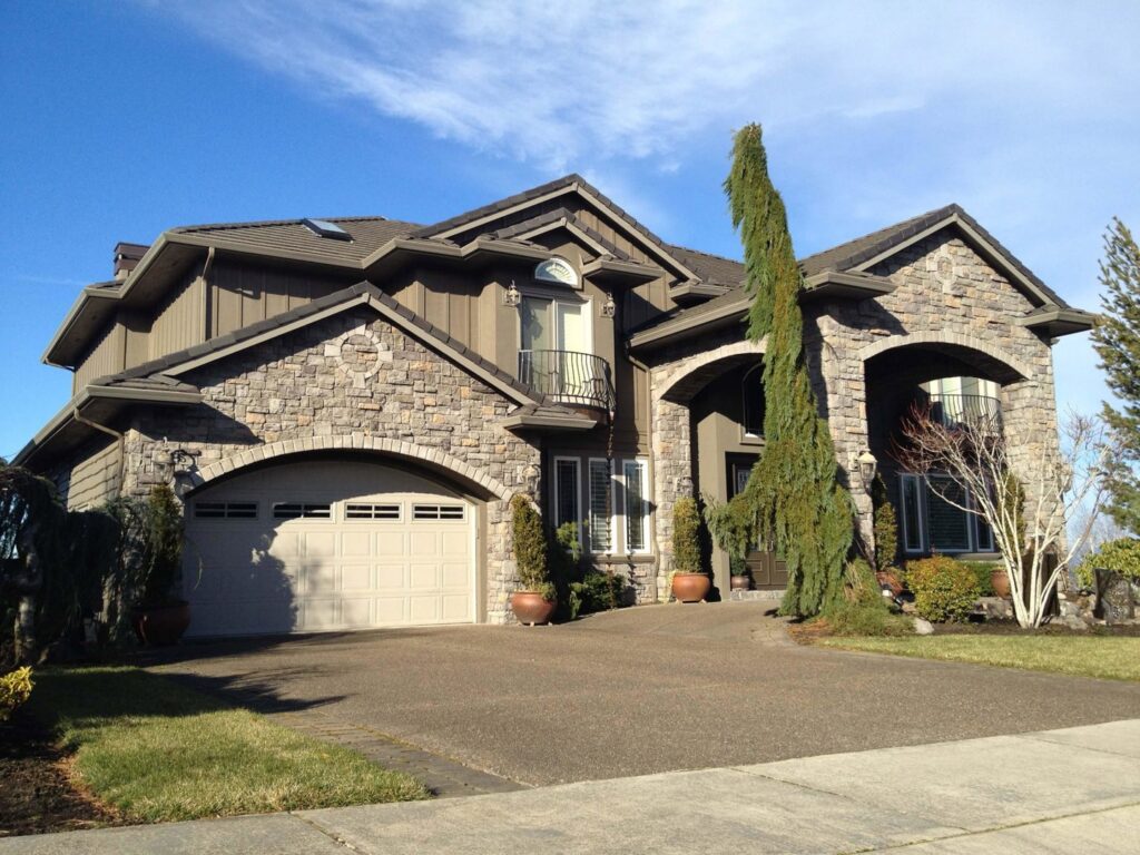 A large custom home featuring stone veneer and vertical siding by Lifetime Remodeling Systems in Portland, OR.