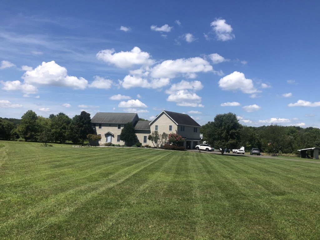 A large residential property with a beautifully mowed lawn, demonstrating professional service from Neace's Lawn Care LLC in Martinsburg, WV.