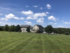 A large residential property with a beautifully mowed lawn, demonstrating professional service from Neace's Lawn Care LLC in Martinsburg, WV.