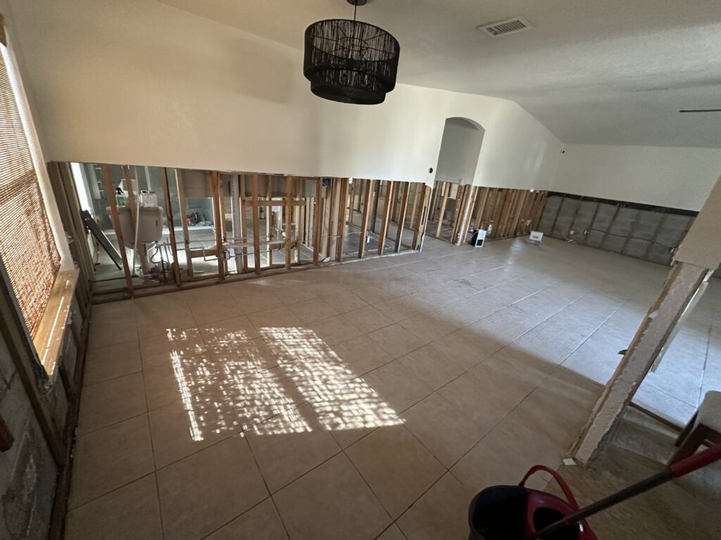 A large room with lower drywall removed, exposing studs and concrete blocks for water damage remediation by Catalyst Restoration in Hagerstown, MD.