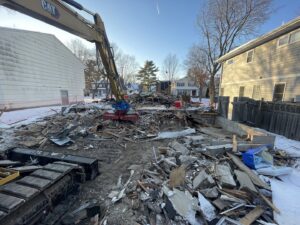 A large-scale demolition site with an excavator and debris piles by Rick's Demolition and Concrete Removal in Minneapolis, MN