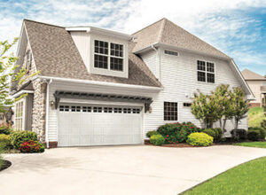 A large white panel garage door with decorative windows on a residential house, installed by K & B Door Co. in Las Vegas, NV