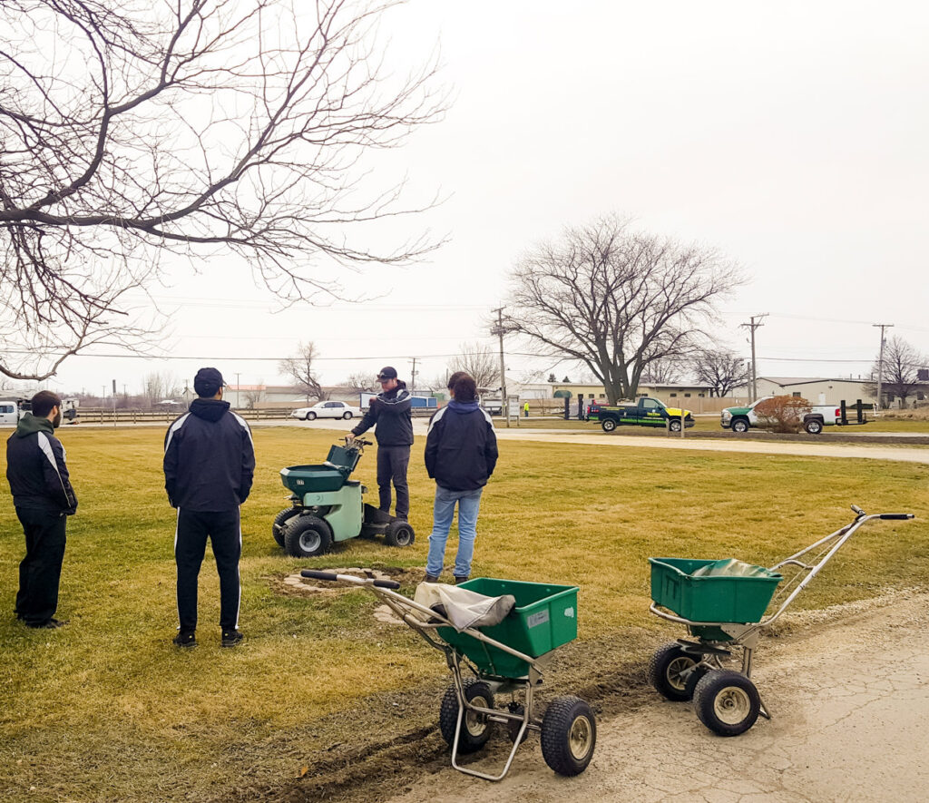 A team of lawn care professionals with spreaders and equipment from Tee Time Lawn Care Davenport, IA.