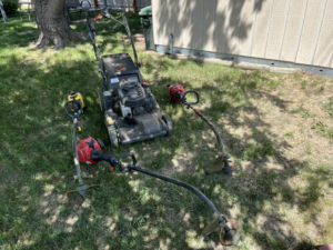 Lawn care equipment including a mower and string trimmers on grass for Bucks Lawn Care LLC in Lincoln, NE.