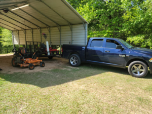 A truck and trailer with professional lawn care equipment, including a zero-turn mower, from Caffey's Lawn Care LLC in Jackson, MS.