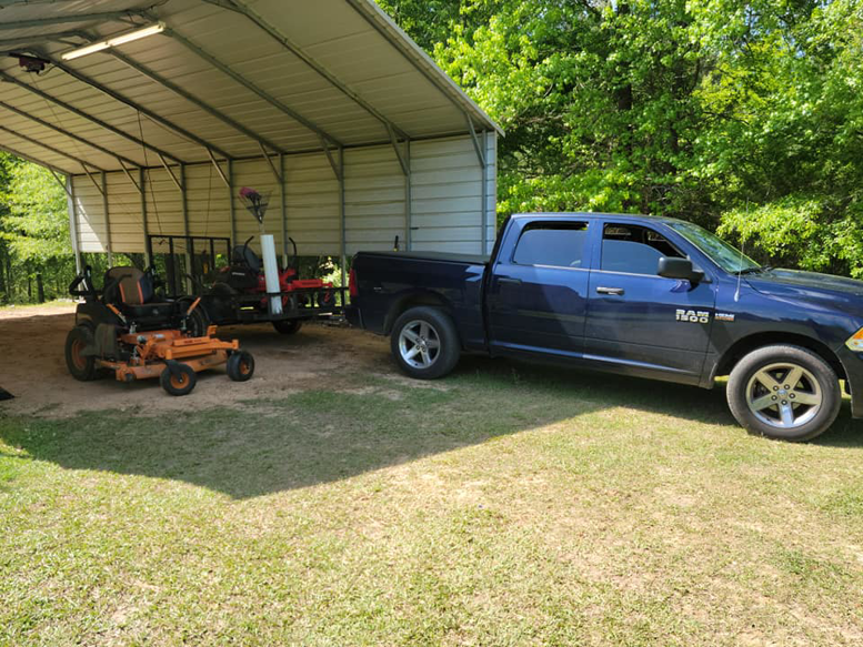 A truck and trailer with professional lawn care equipment, including a zero-turn mower, from Caffey's Lawn Care LLC in Jackson, MS.
