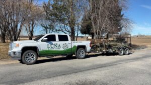 Luna's Lawn Care LLC truck with a trailer full of yard debris, ready for removal in West Des Moines, IA.
