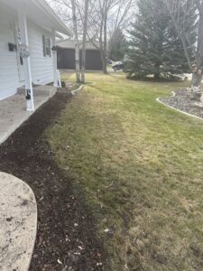 A lawn area showing preparation for new planting or mulching, a service offered by Matt's Lawn Service in Casper, WY.