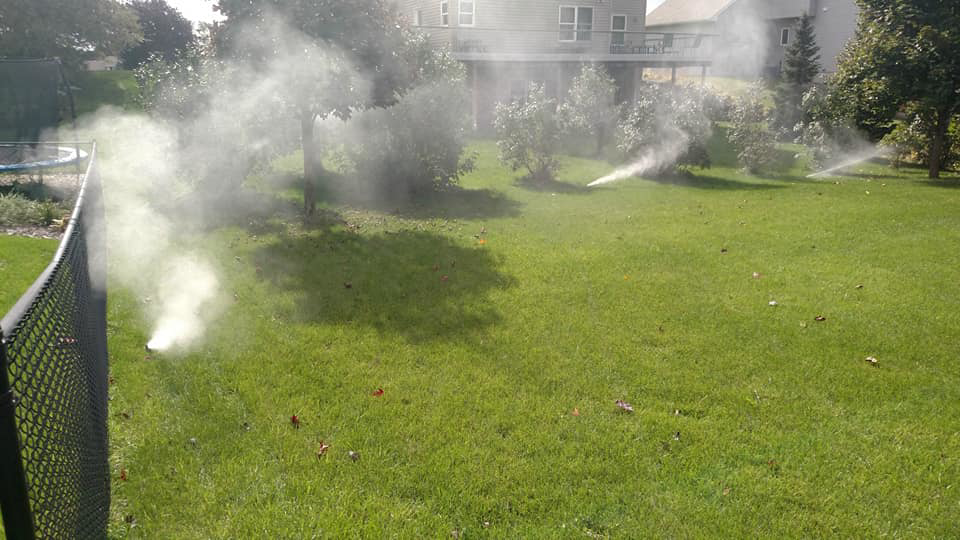 Multiple sprinklers watering a lush green lawn, showing irrigation services by Love it Lawn Care in Butte, MT