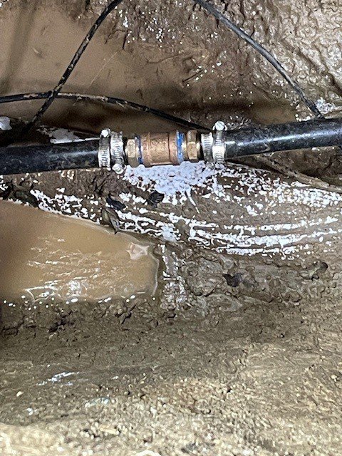 A leaking pipe connection underground, showing water damage being addressed by DNA Drain Cleaning & Sewer in Tulalip, WA.