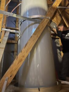 A leaking water heater in an attic with water collected in the pan, showing water damage by Plumb Pro in Mountlake Terrace, WA.