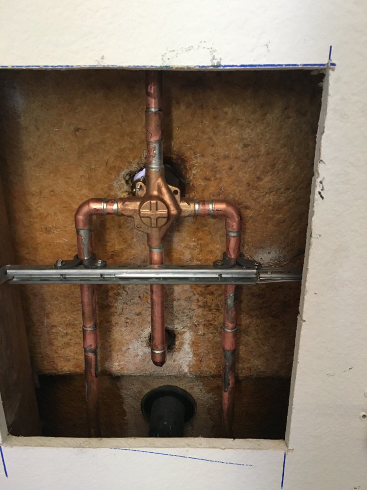 A leaking water heater causing water damage on the floor, addressed by Duda Plumbing Inc in Cypress, CA.