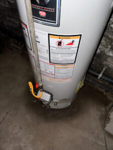 A water heater with water stains and pooling around its base, a common source of water damage addressed by KY Water Damage Restoration in Georgetown, KY.