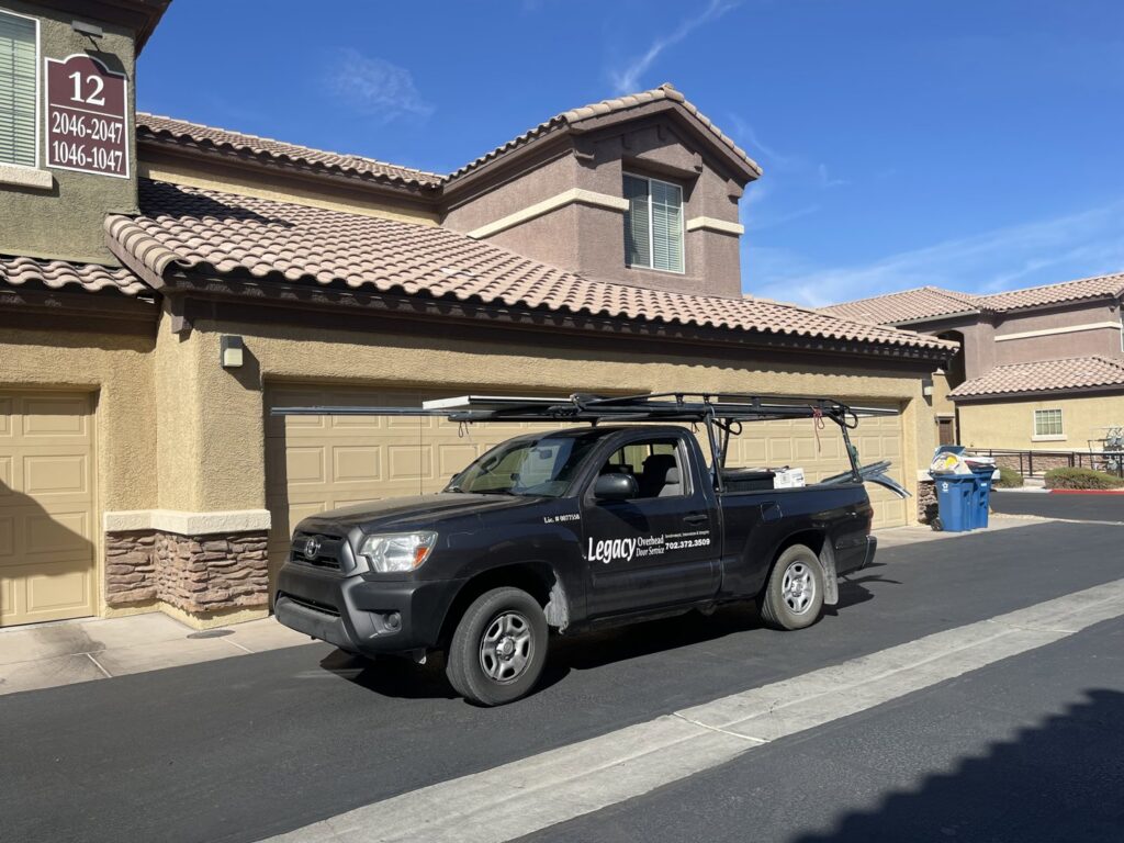 A Legacy ODS Garage Door Services truck parked at a job site in front of garage doors in Las Vegas, NV.