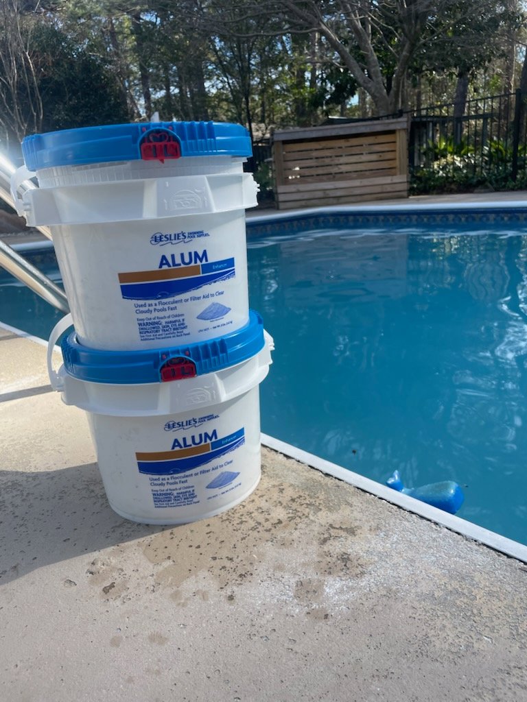 Buckets of Leslie's Alum pool clarifier by the poolside, used by Pool Services of Wilmington in Wilmington, NC.