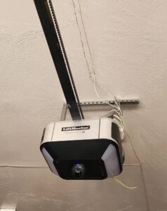 A LiftMaster garage door opener installed on a garage ceiling by Quality-Brand Garage Doors in Rio Rancho, NM.