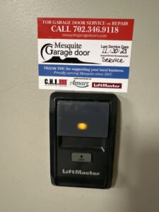 A LiftMaster garage door opener control panel with a service sticker from Garage Door Mesquite, showing a recent service date in Mesquite, NV.