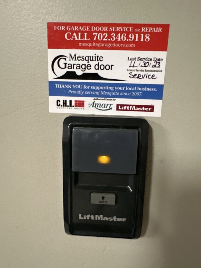 A LiftMaster garage door opener control panel with a service sticker from Garage Door Mesquite, showing a recent service date in Mesquite, NV.