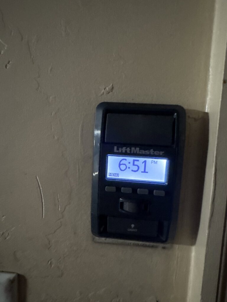 A close-up of a LiftMaster garage door opener wall control panel, indicating a service provided by Overhead Door Company of Salt Lake in Sandy, UT.