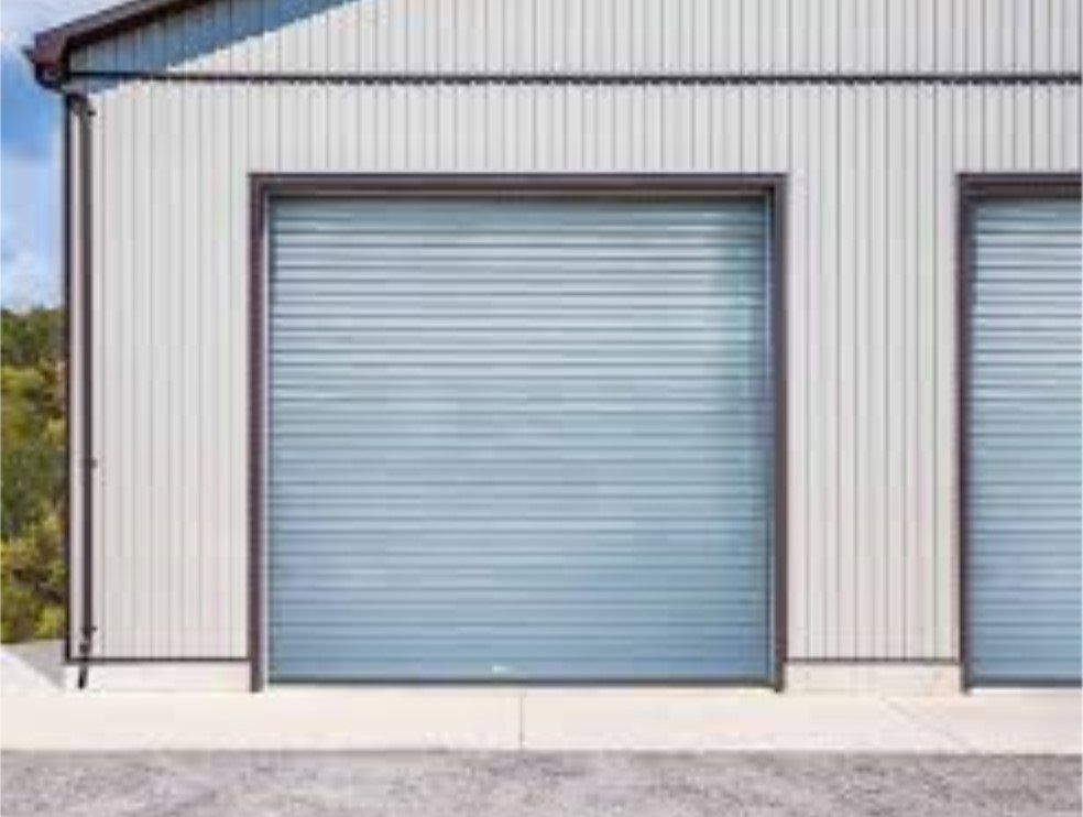 A light blue rolling steel garage door installed on a corrugated metal building by Wayne Dalton Sales & Service of Quad Cities in Davenport, IA.