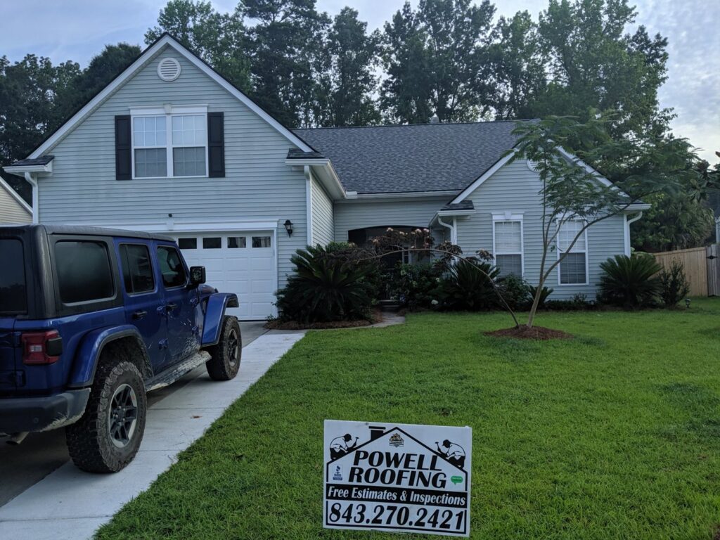 A residential home with light blue siding and a new roof, completed by Powell Roofing in Ladson, SC.