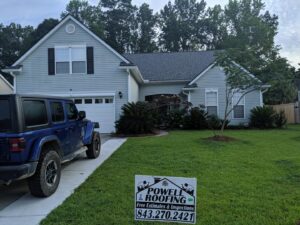 A residential home with light blue siding and a new roof, completed by Powell Roofing in Ladson, SC.