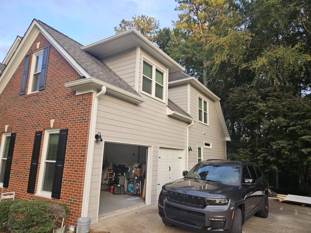 A residential home with new light gray siding and brick accents installed by HP Exteriors in Woodstock, GA