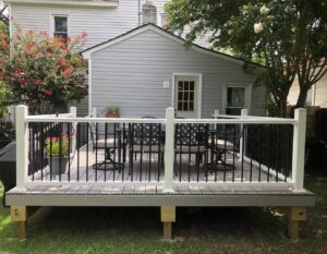 A backyard shed with light gray siding and a new deck by Cordell Exteriors Inc in Chesapeake, VA