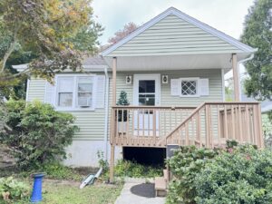 A charming small house with newly installed light green horizontal siding by DL Roofing and Siding in New Haven, CT