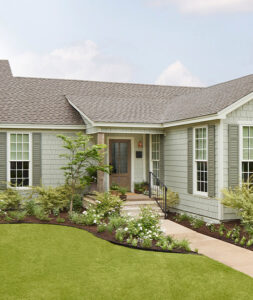 A beautiful home featuring light green shake siding and white trim, a project by Bushco Contracting LLC in Fresno, CA.