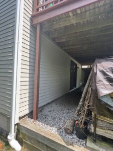 Newly installed light-colored siding on a house section under a deck by J&J Rivera Roofing and Supply Co in Old Saybrook, CT