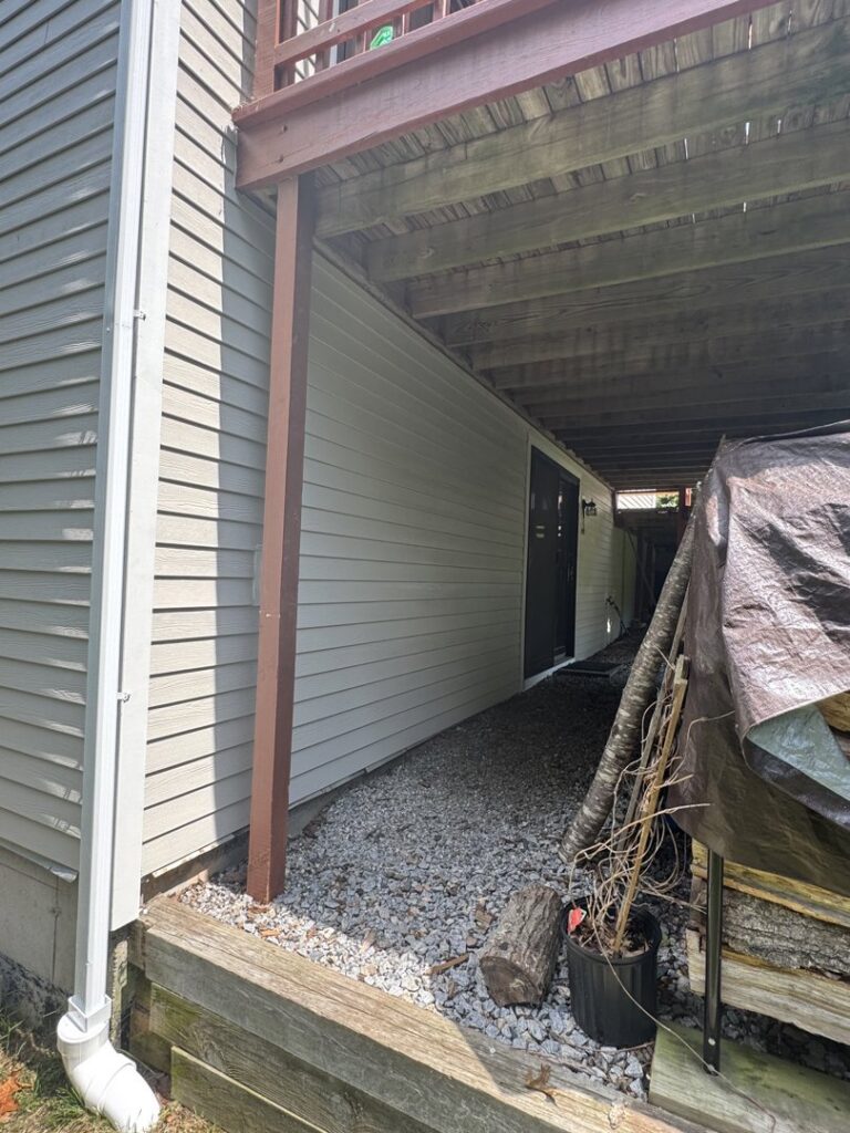 Newly installed light-colored siding on a house section under a deck by J&J Rivera Roofing and Supply Co in Old Saybrook, CT