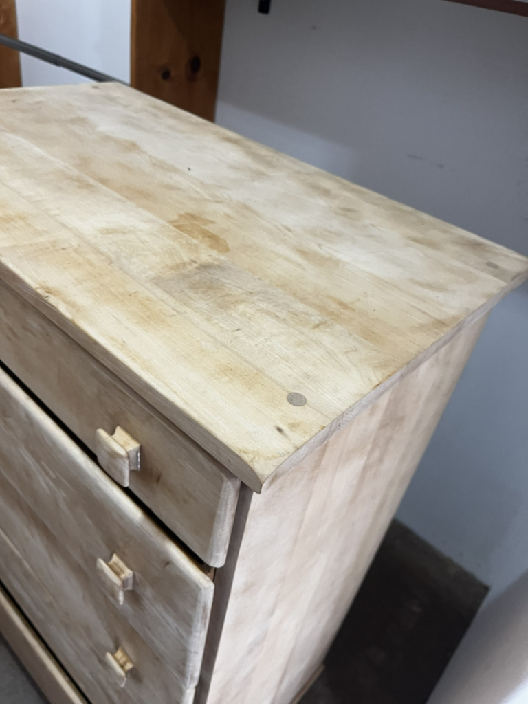 The top of a light wooden dresser showing light stains, ready for cleaning by Clean & Clear Pros LLC in Timm Place, USA.