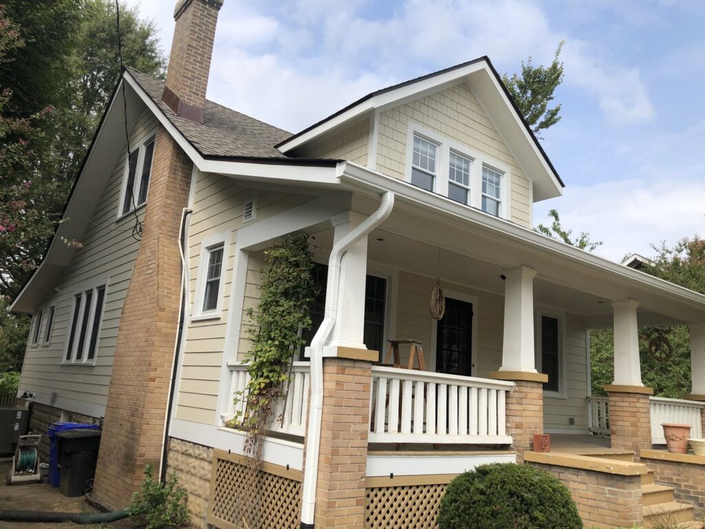 Beautiful house with new light yellow horizontal siding and shake siding in the gable by High Quality Exteriors in Rockville, MD.