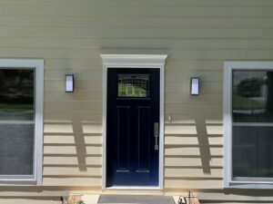 A house with new light yellow siding and a contrasting dark blue front door by HP Exteriors in Woodstock, GA