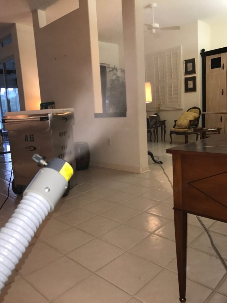 A living room being treated with a fogging device and large restoration equipment by Southcoast Cleaning Solutions & Restoration in Fall River, MA.