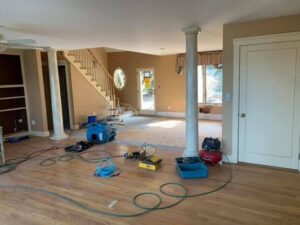 Water damage drying equipment, including air movers, set up in a living room by Clean Care of New England in Cranston, RI