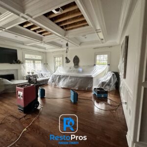 Water damage drying equipment and covered furniture in a living room undergoing restoration by RestoPros Hudson County in Jersey City, NJ.