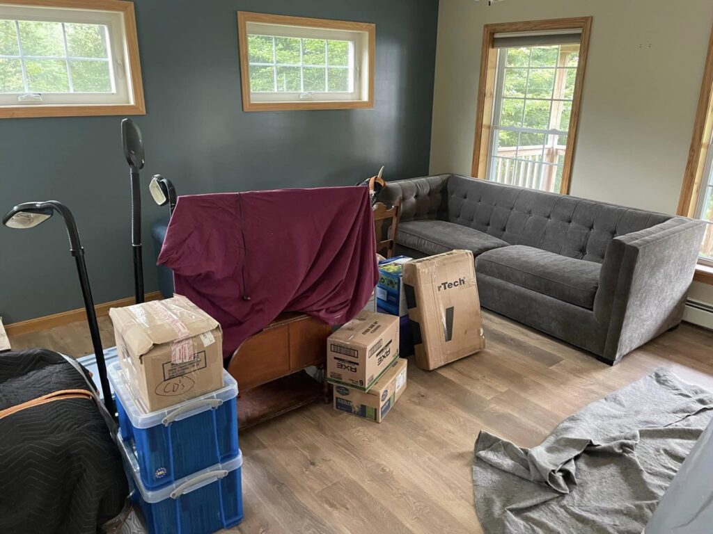 A living room filled with packed boxes and wrapped furniture, ready for moving by Next Step Moving in Eau Claire, WI.