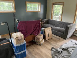 A living room filled with packed boxes and wrapped furniture, ready for moving by Next Step Moving in Eau Claire, WI.