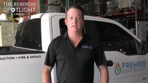 Two water damage specialists loading drying equipment into a company van for Premier Restoration Hawaii in Honolulu, HI.