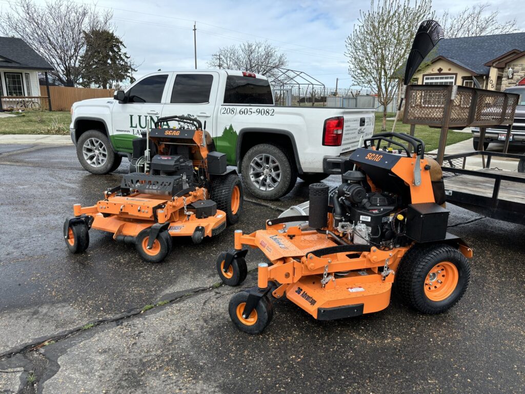 Two professional zero-turn mowers and a Luna's Lawn Care LLC truck, showcasing equipment in West Des Moines, IA.