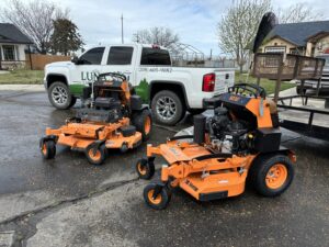 Two professional zero-turn mowers and a Luna's Lawn Care LLC truck, showcasing equipment in West Des Moines, IA.
