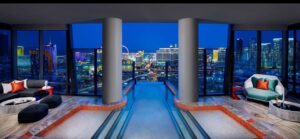 A luxurious indoor pool integrated into a modern living space with a city skyline view, designed by Purpose Pools in Henderson, NV.