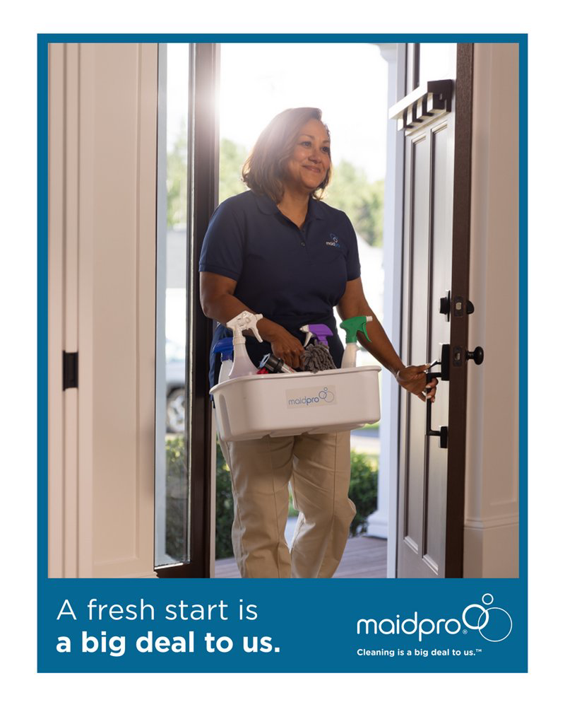 A MaidPro Wichita cleaner arriving at a client's home with a caddy of cleaning supplies in Wichita, KS.