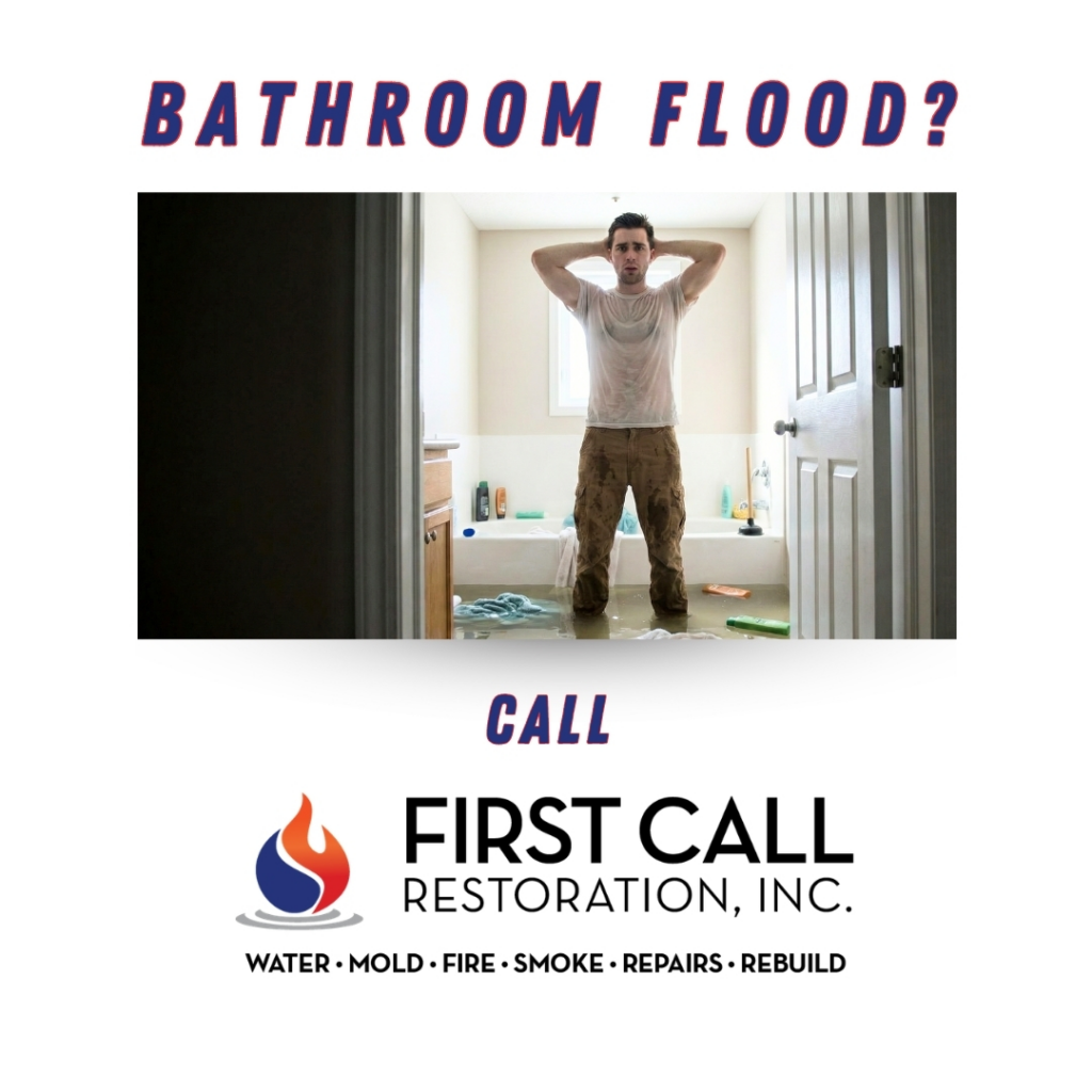 A man standing in a severely flooded bathroom, indicating water damage, handled by First Call Restoration in Kansas City, MO.