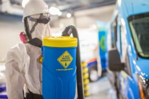 A mannequin in a hazmat suit with a backpack sprayer, representing safety protocols for 1-800 WATER DAMAGE of Oklahoma City, OK.