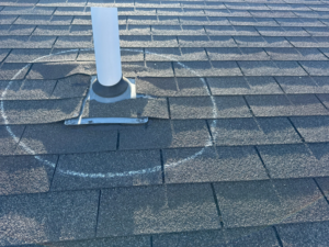 A roof vent pipe with a chalk circle marking a potential leak source for Sharp Restoration in Lincoln, NE.