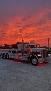 A McDowell Wrecker Service heavy-duty tow truck illuminated at sunset in Springfield, MO.